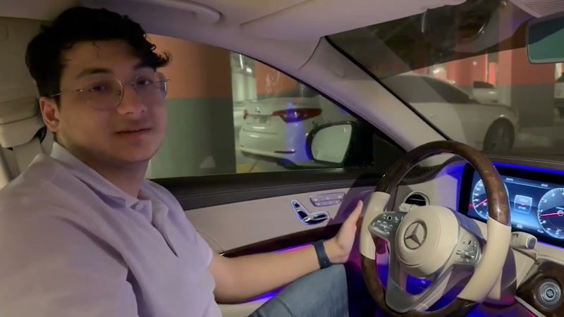 Amer at the wheel of a 2018 Mercedes-Benz S560 with blue ambient lighting.